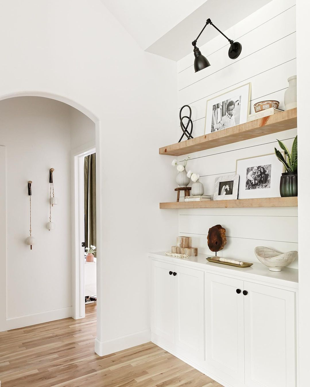 This Living Room Boasts Warm Wood Floors And A Black Lamp Hanging On A ... for Integrating Warmth Understanding the Floating Welcome Shelf's Appeal
