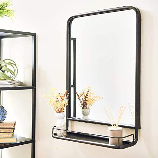 A Mirror Sitting On Top Of A Shelf Next To A Plant in Styling Tips for Your New Modern Metal Framed Mirror With Shelf